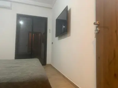 a bedroom with a bed and a television on a wall at Family apart in Marrakech