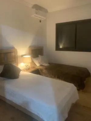a bedroom with two beds and a tv on the wall at Family apart in Marrakech