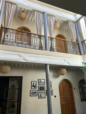 a building with a balcony and a wooden door at Riad Al Nubala in Marrakech