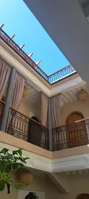 a large building with a balcony with curtains at Riad Al Nubala in Marrakech