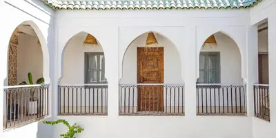a white building with arches and a wooden door at RIAD 48 & SPA in Marrakech