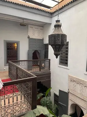 a room with a balcony with a chandelier at BKAN RIAD MARRAKECH in Marrakech