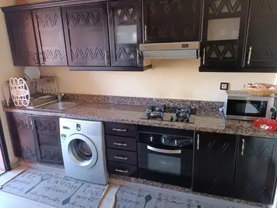 a kitchen with a washing machine and a sink at un moderne chic appartement vue sur piscine in Marrakech