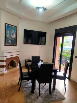 a dining room with a table and chairs and a fireplace at un moderne chic appartement vue sur piscine in Marrakech