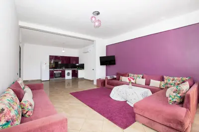 a living room with two couches and a purple wall at lafamilia in Marrakech