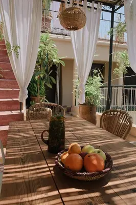 a wooden table with a bowl of fruit on it at Riad Maison 24 in Marrakech