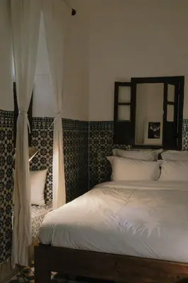a bedroom with a white bed and a mirror at Riad Maison 24 in Marrakech
