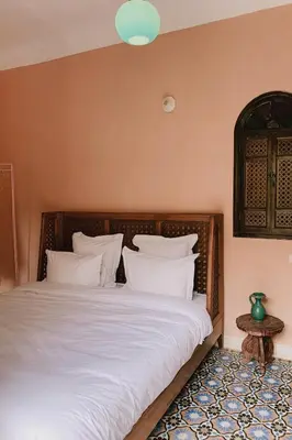 a bedroom with a large bed with white pillows at Riad Maison 24 in Marrakech
