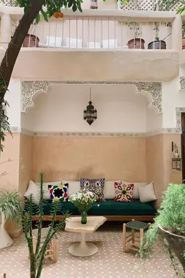 a patio with a green couch and a table at Riad Maison 24 in Marrakech