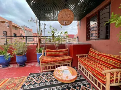 a patio with a couch and chairs on a balcony at Marrakech Mirage Home in Marrakech
