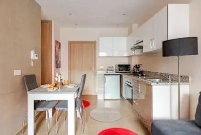 a kitchen with a table and chairs in a room at Coquet studio pour vacance in Marrakech