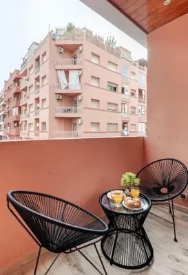 a balcony with two chairs and a table with food on it at Coquet studio pour vacance in Marrakech