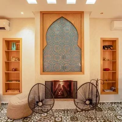 a living room with two chairs and a fireplace at MAISON SOLANEOS in Marrakech