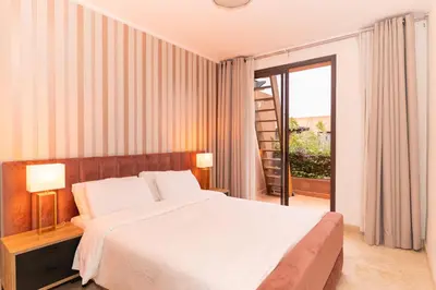 a bedroom with a large bed and a balcony at Pavillon Affaoui Golf & Waky in Marrakech