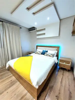 a bedroom with a large bed with a yellow blanket at Appartement pour Familles en Résidence-Piscine et WiFi Fibre Optique in Marrakech