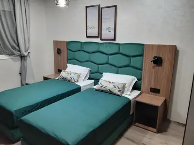 a bedroom with two beds and a green headboard at Appartement pour Familles en Résidence-Piscine et WiFi Fibre Optique in Marrakech