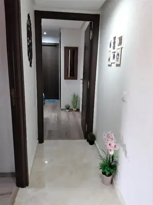 a hallway with two doors and flowers in a room at Appartement pour Familles en Résidence-Piscine et WiFi Fibre Optique in Marrakech