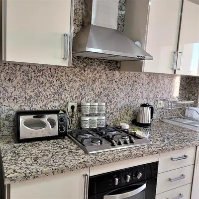 a kitchen with a stove top oven and a microwave at Appartement pour Familles en Résidence-Piscine et WiFi Fibre Optique in Marrakech