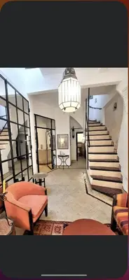 a living room with a staircase and a chandelier at Riad privatisé jusqu a 5 personnes a 5 minutes place jemma El fna loué avec ménage et petit déjeuner compris in Marrakech