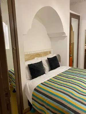 a bedroom with a bed with a colorful striped blanket at Riad privatisé jusqu a 5 personnes a 5 minutes place jemma El fna loué avec ménage et petit déjeuner compris in Marrakech