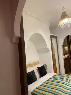 a bedroom with a bed with a colorful striped blanket at Riad privatisé jusqu a 5 personnes a 5 minutes place jemma El fna loué avec ménage et petit déjeuner compris in Marrakech