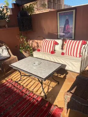 a patio with a couch and a coffee table at Riad privatisé jusqu a 5 personnes a 5 minutes place jemma El fna loué avec ménage et petit déjeuner compris in Marrakech