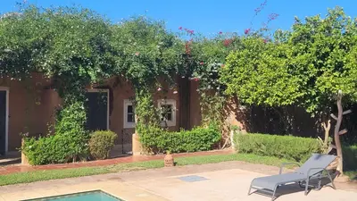 a house with a chair and a swimming pool at Maison ALPHEA SPA HAMMAM in Marrakech