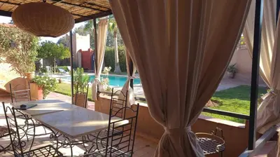 a patio with a table and chairs and a pool at Maison ALPHEA SPA HAMMAM in Marrakech