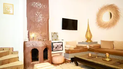 a living room with a couch and a fireplace at Ryad de charme authentique piscine calme in Marrakech