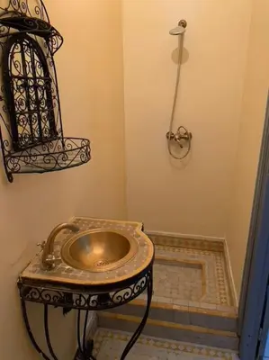 a bathroom with a metal sink and a shower at Ryad de charme authentique piscine calme in Marrakech