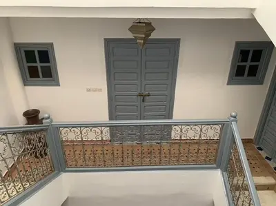 a staircase with a gray door and a stair railing at Ryad de charme authentique piscine calme in Marrakech