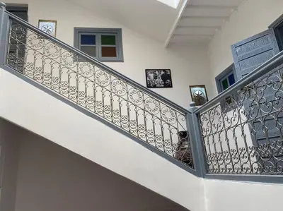 a staircase with a wrought iron railing at Ryad de charme authentique piscine calme in Marrakech