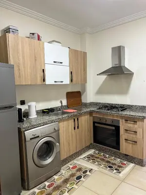 a kitchen with a sink and a washing machine at Appartement avec piscine in Marrakech
