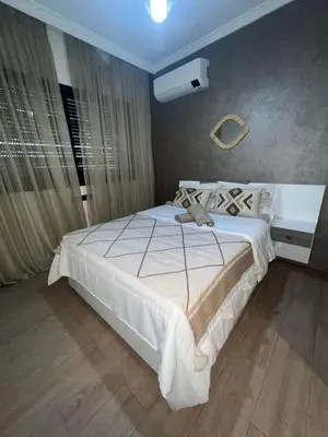 a bedroom with a large white bed in a room at Appartement avec piscine in Marrakech