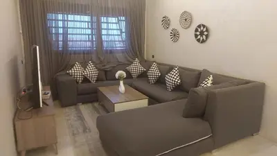 a living room with a couch and a table at Appartement avec piscine in Marrakech