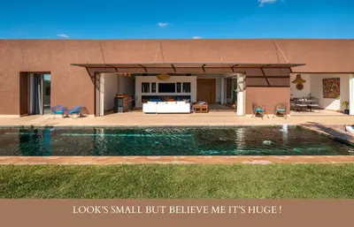 a house with a swimming pool in front of a house at Villa Zen'O Palmeraie - Hot Pool in Marrakech
