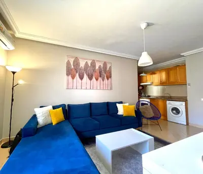 a living room with a blue couch and yellow pillows at Sunset Marrakech in Marrakech