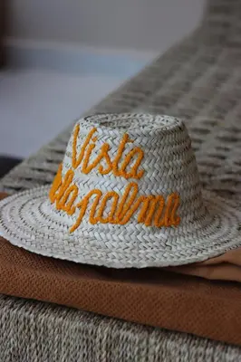a white straw hat sitting on top of a bed at Vista de La Palma in Marrakech