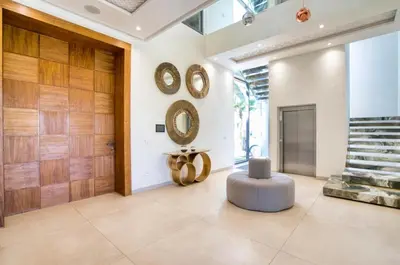 a lobby with a round ottoman and clocks on the wall at Villa Simeon Marrakech in Marrakech