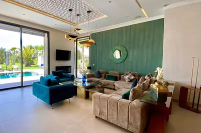 a living room with a couch and blue chairs at Villa Simeon Marrakech in Marrakech