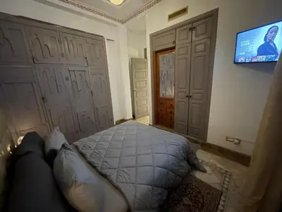 a bedroom with a bed and a flat screen tv at Au Cœur de la Palmeraie de Marrakech in Marrakech