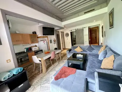 a living room with a blue couch and a kitchen at Au Cœur de la Palmeraie de Marrakech in Marrakech