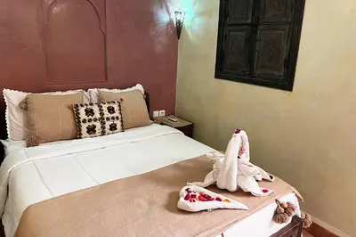 a bedroom with a bed with two stuffed animals on a table at Dar Ben Saleh in Marrakech
