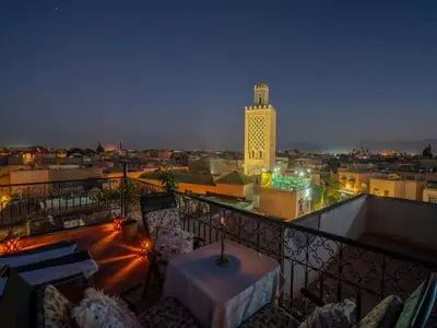 a balcony with a view of a city at night at Dar Ben Saleh in Marrakech