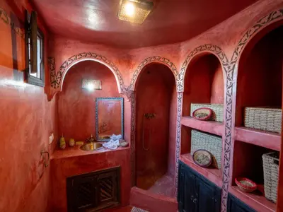 a bathroom with red walls and a sink and shelves at Dar Ben Saleh in Marrakech