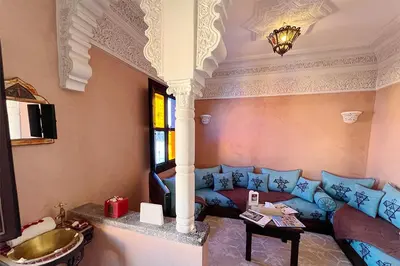 a living room with a blue couch and a sink at Dar Ben Saleh in Marrakech