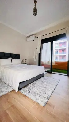 a bedroom with a large bed and a large window at Luxury apartment Gueliz (2 min walk from Train Station) in Marrakech