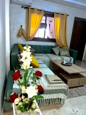 a living room with a green couch and a table at Luxury apartment Gueliz (2 min walk from Train Station) in Marrakech