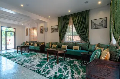 a living room with green couches and a rug at Yanis Guest House in Marrakech