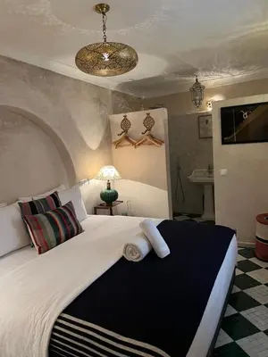 a bedroom with a large bed with towels on it at Riad Alena in Marrakech